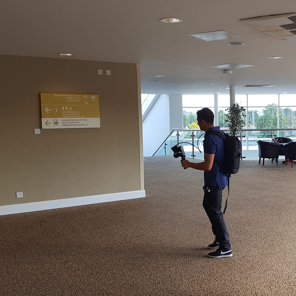 Man walking through a foyer with mobile laser scanner